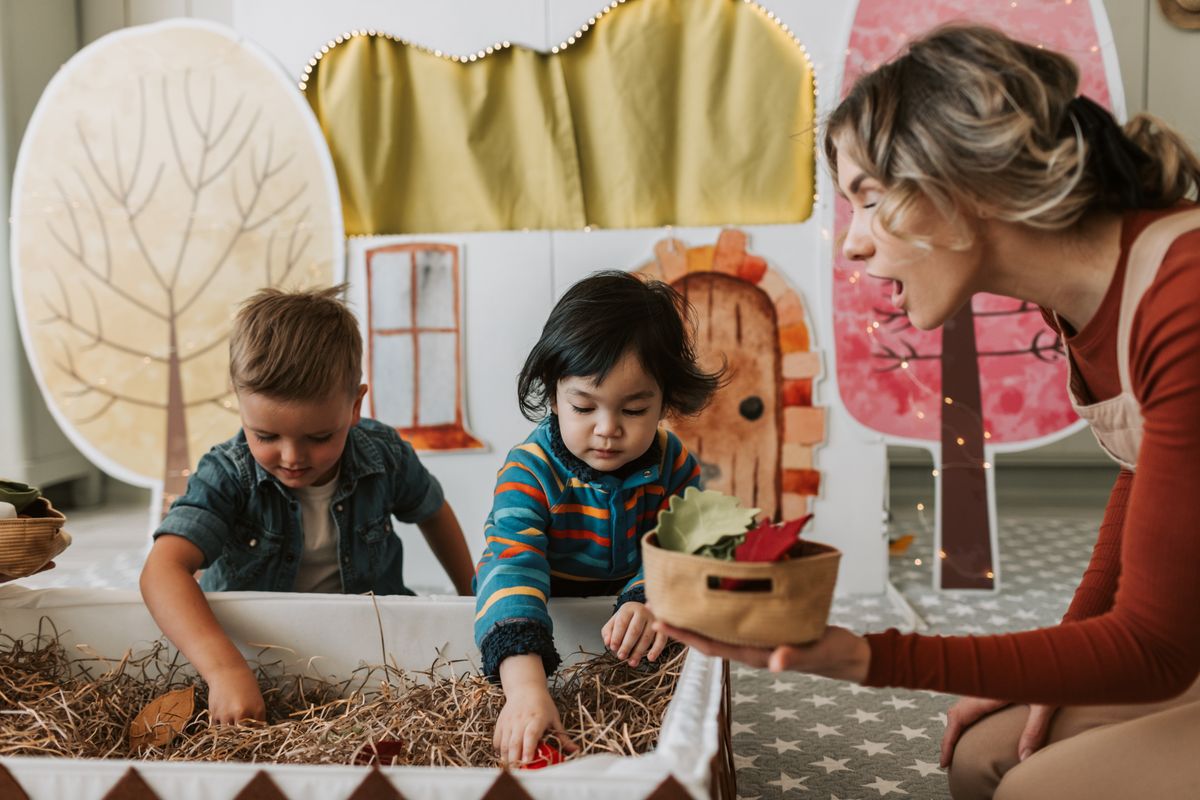 Adult playing on the floor with young children during an evaluation session