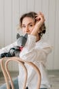 Girl in White Long Sleeve Shirt Sitting on White Chair