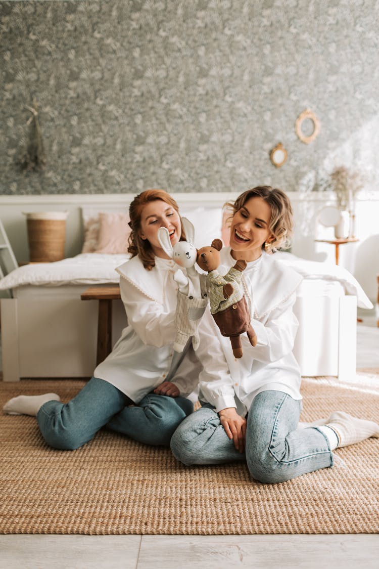 Two Women Playing Puppets While Sitting On The Floor