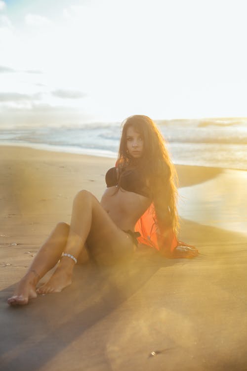 Woman in Bikini Sitting on Shore