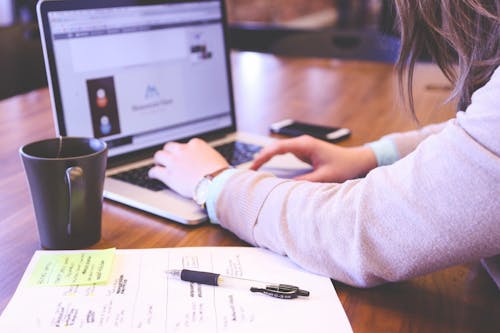 Free Person Using Laptop Computer on Table Stock Photo