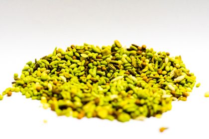 A mound of whole fennel seed on a white background. Photo by Kam Photos on Pexels.