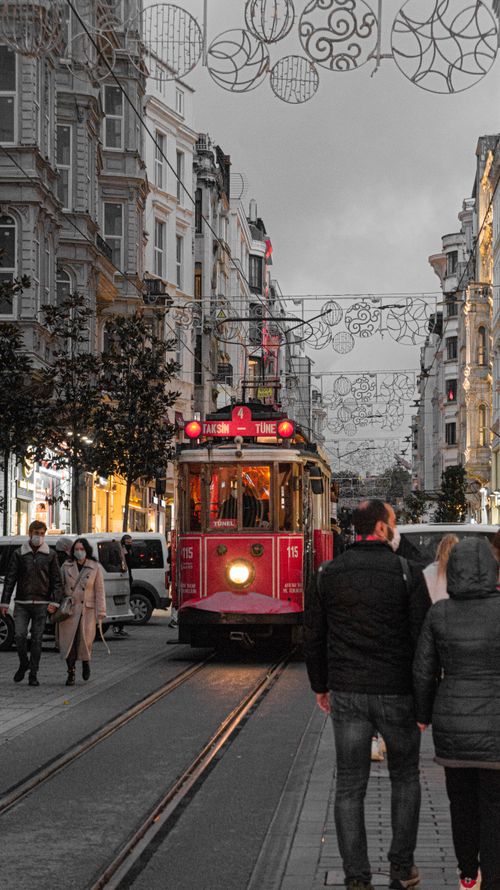 Free Red tram travels down İstiklal Avenue in Istanbul, capturing the bustling city's charm at dusk. Stock Photo