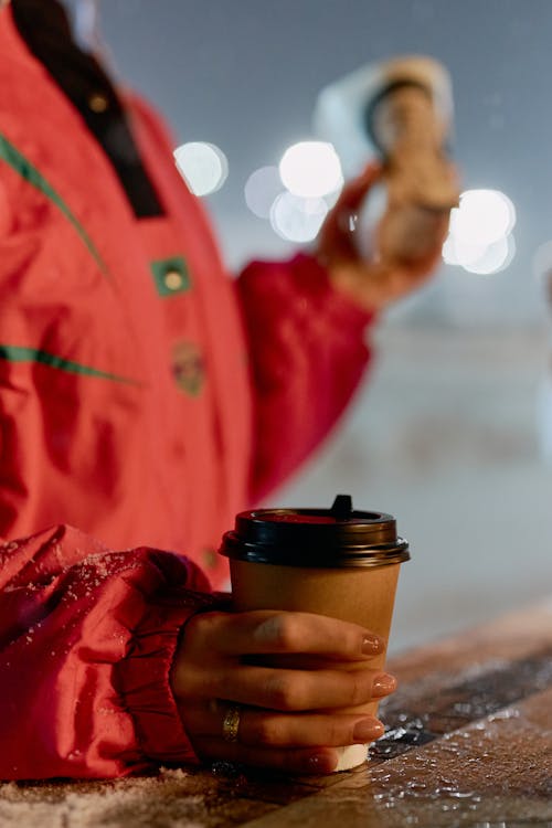 Free Person in Red Jacket Holding Cup of Coffee Stock Photo