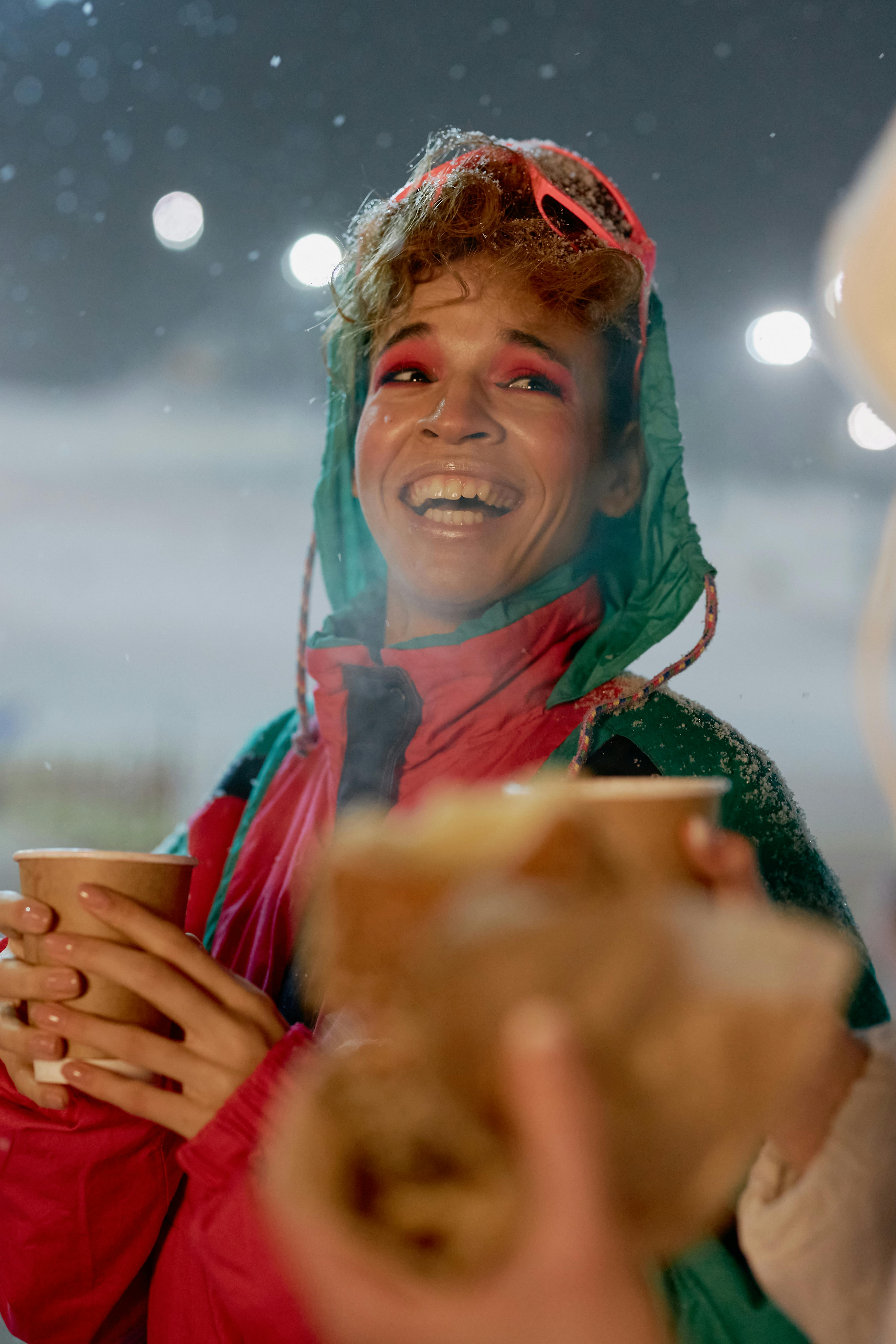 happy woman in green and red snowboard jacket