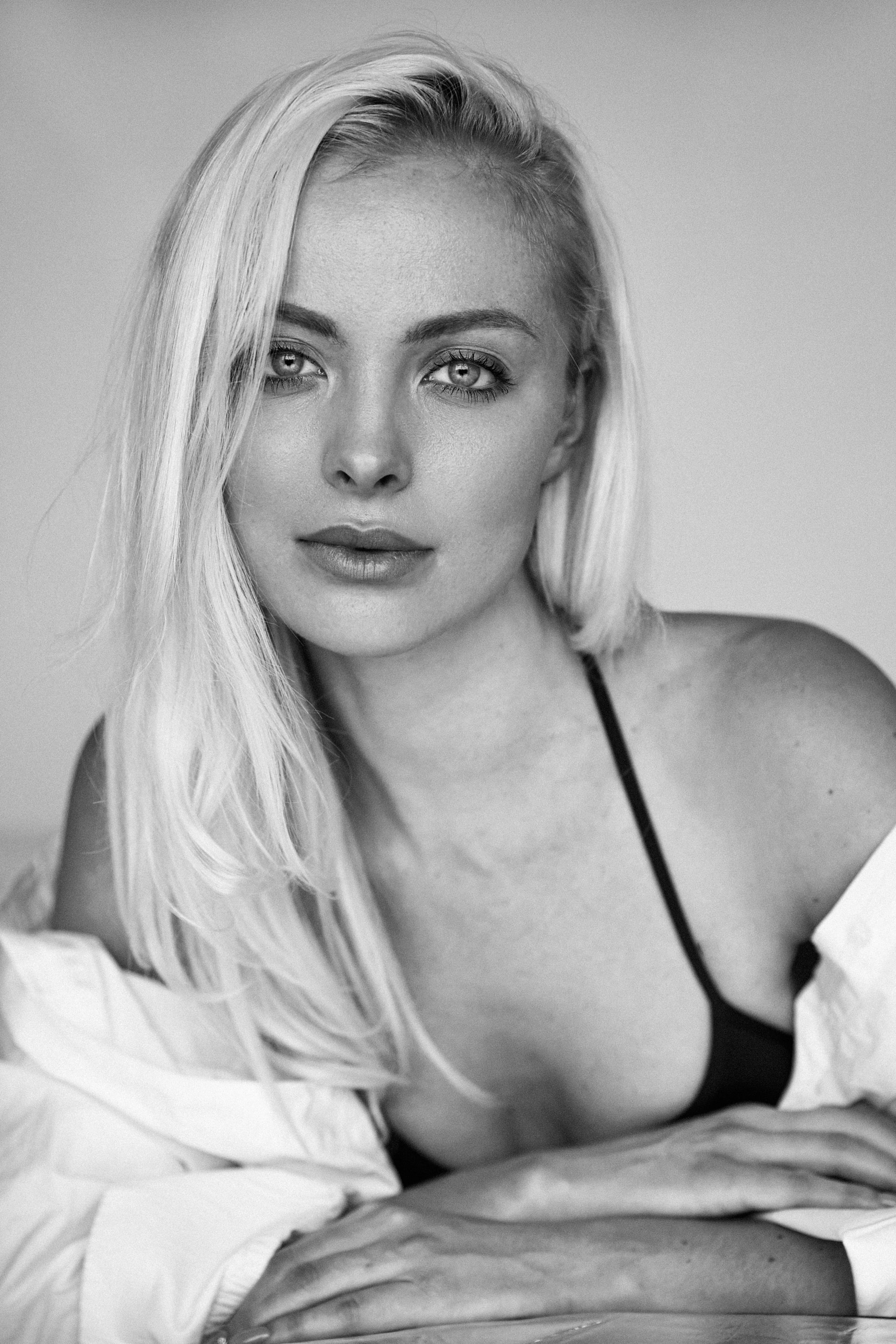 Graceful black and white portrait of a woman in lingerie with soft expression.