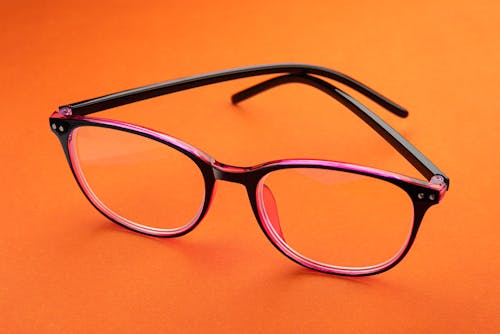 An Eyeglasses on Orange Surface