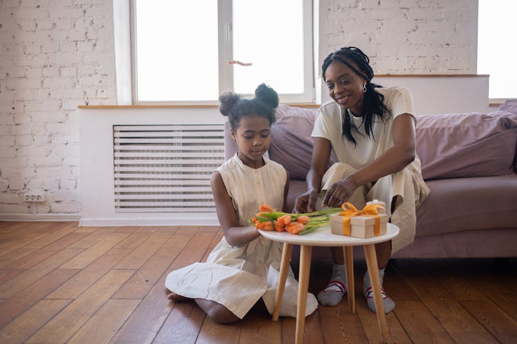 A Mother Talking To His Daughter While Sitting On The Couch