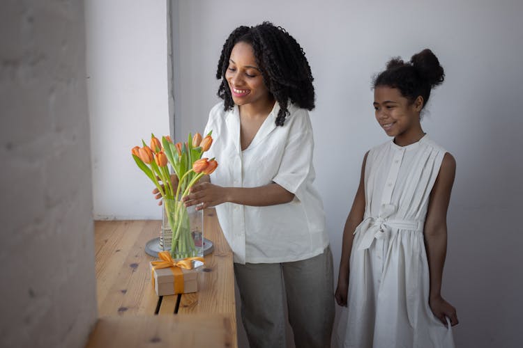 Woman Putting Flowers In A Vase