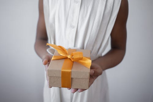 Free Person Holding a Gift with Yellow Ribbon Stock Photo