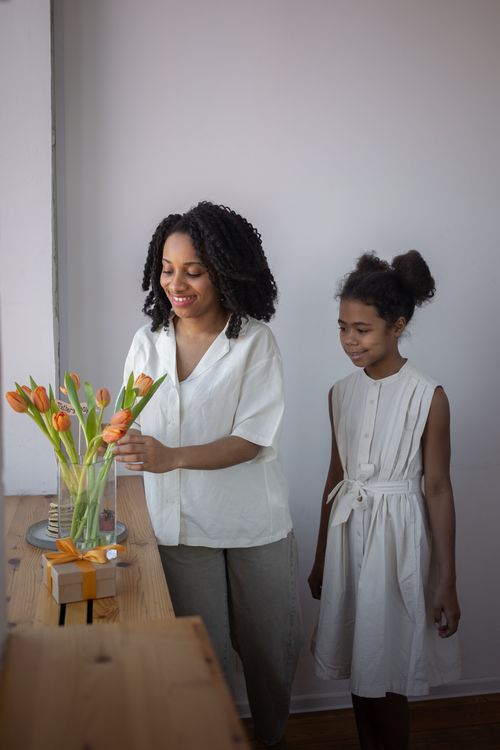 Free A mother and daughter joyfully arranging tulips for Mother's Day at home. Stock Photo