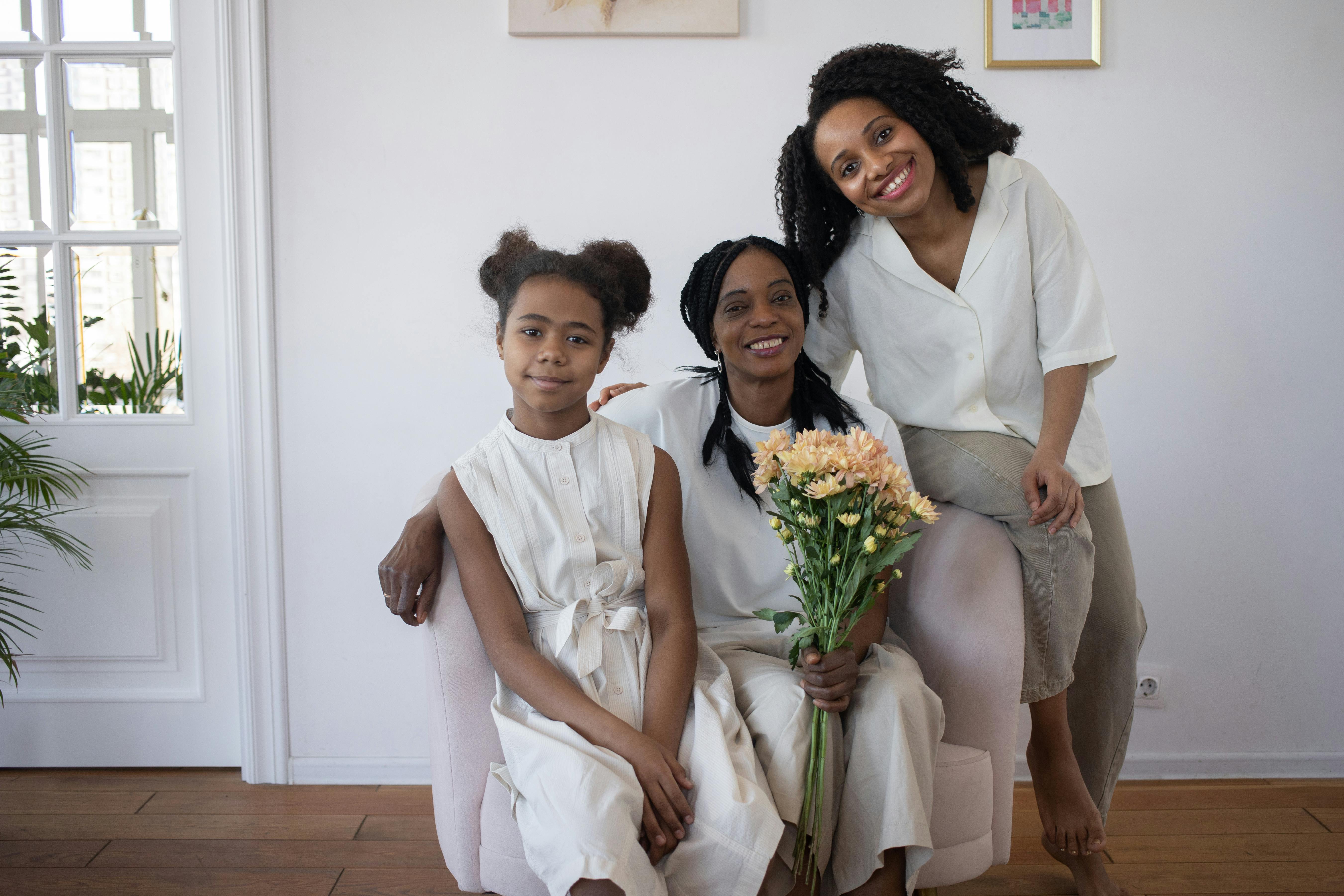 Free Three Women Smiling and Sitting Side By Side Stock Photo