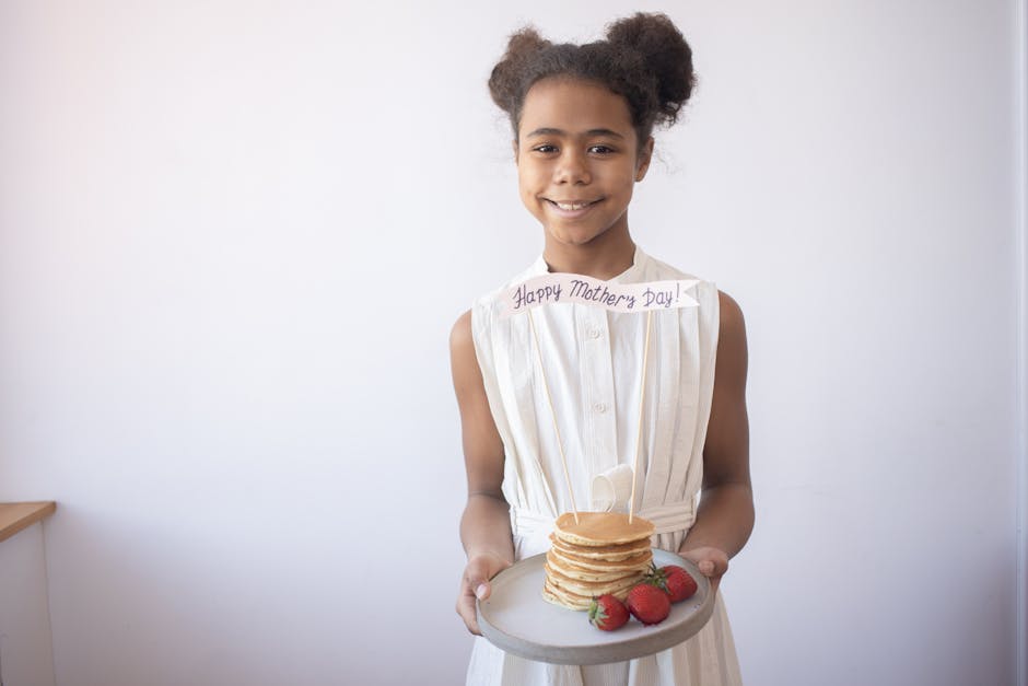 A person holding a container of homemade food, smiling and looking at the camera, with a diverse spread of dishes in the background.