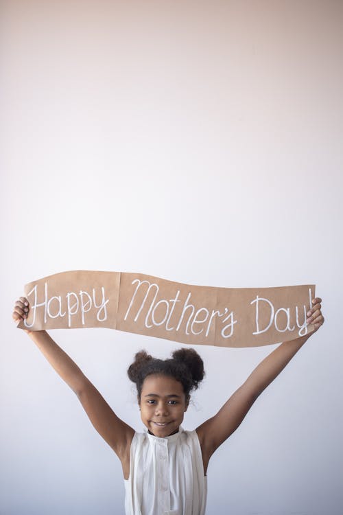 A Girl Holding a Happy Mother's Day Banner