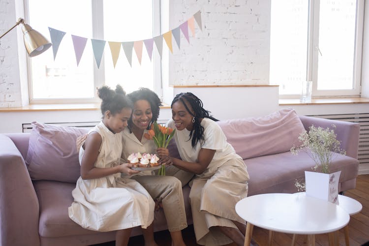 A Happy Family Sitting On The Couch While Having Conversation