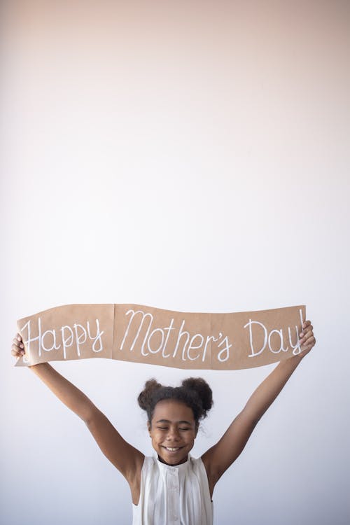 A Child Holding Happy Mother's Day Banner