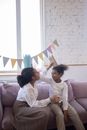 Mother and Child Putting Paper Crowns on Their Head