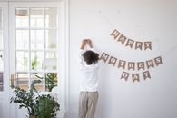A Girl Hanging a Banner on a White Wall
