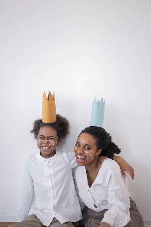 Free Mother and Daughter with Face Stickers Wearing `Party Hats Stock Photo