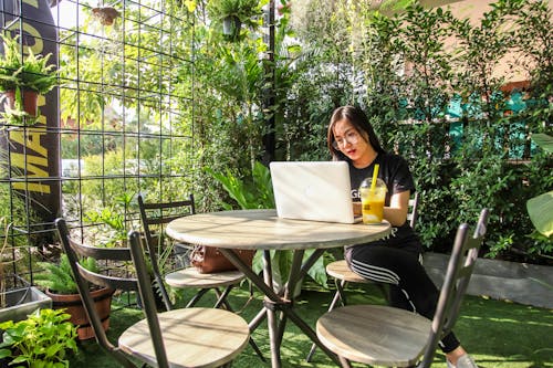 Mujer Sentada En Una Silla Mientras Usa La Computadora Portátil