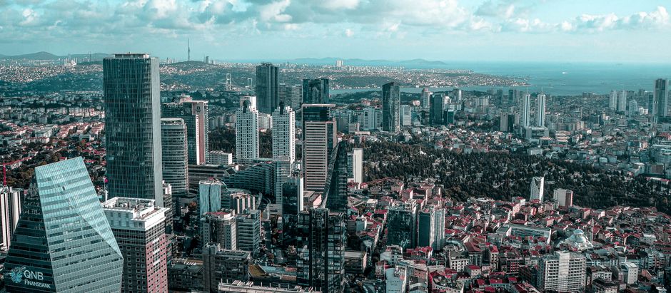 Aerial view of Istanbul's modern skyline with high-rise buildings and Bosporus in sight.