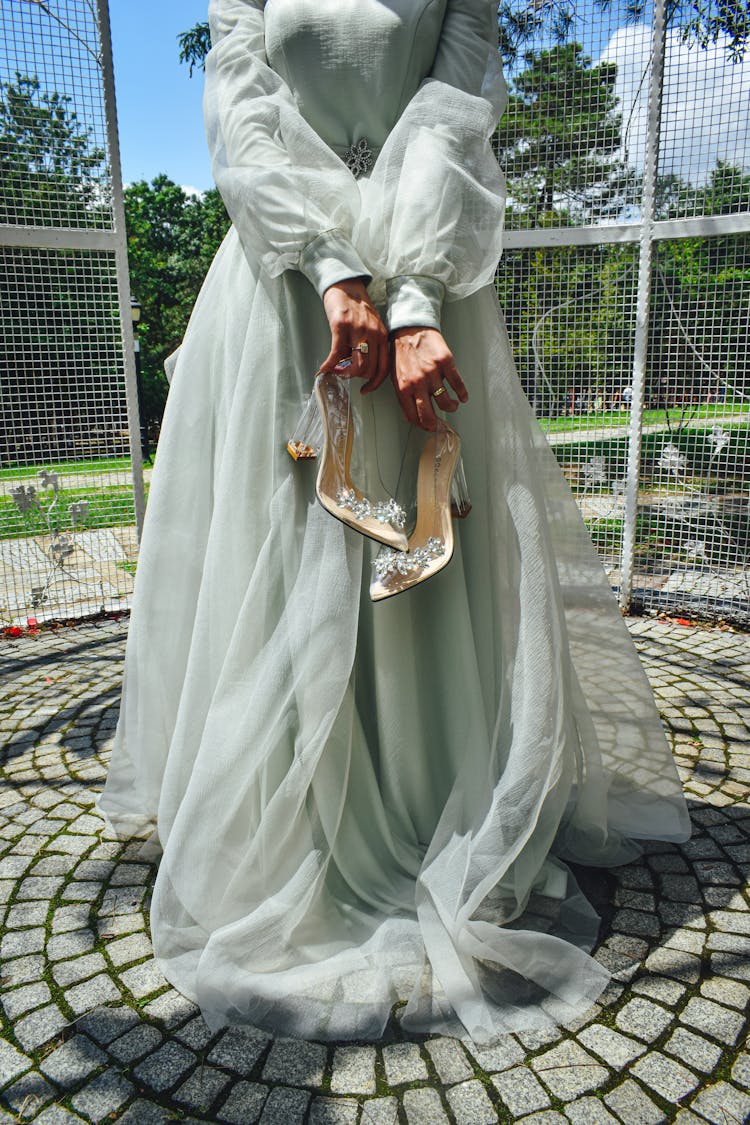 A Woman Holding Transparent Pumps
