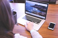 Woman Using Macbook Pro on Table