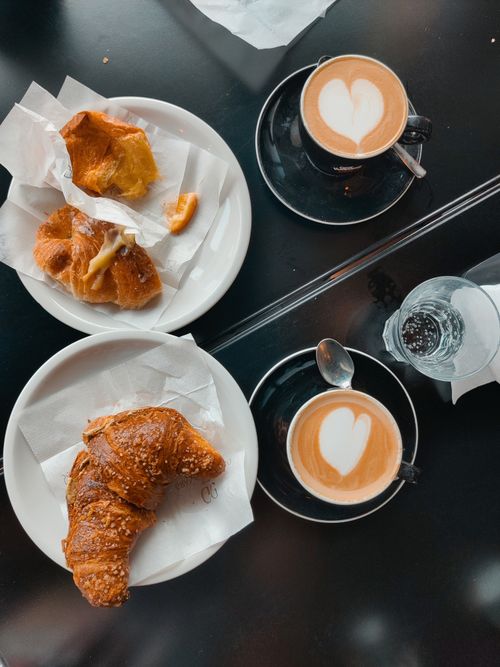 Free Top view of croissants and coffee with heart latte art at a cafe in Latina, Lazio, Italy. Stock Photo