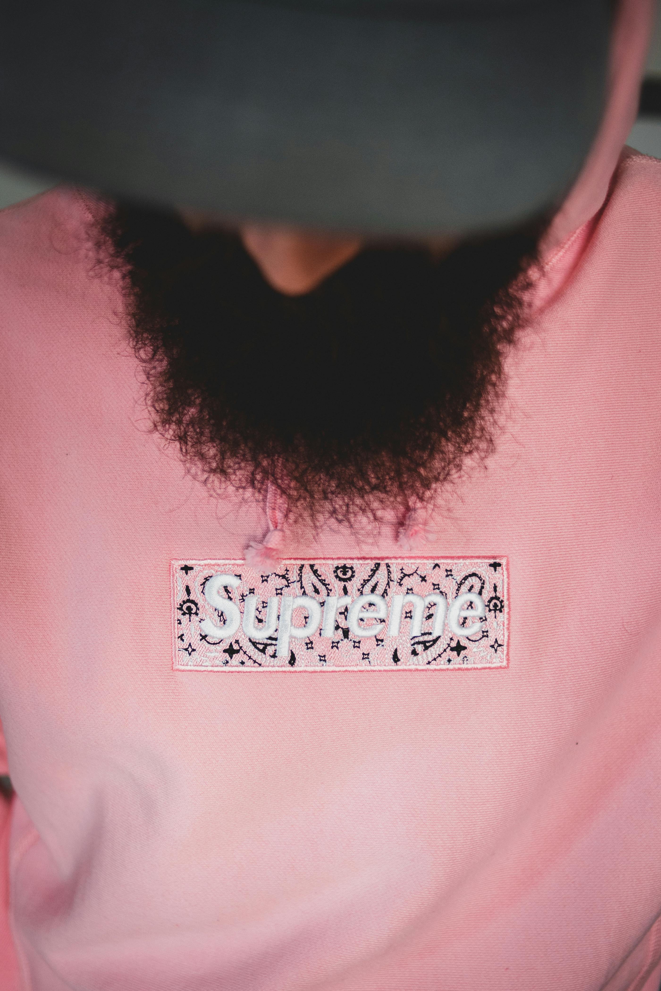 Close-up of a stylish pink hoodie featuring bold logo design and sharp fashion aesthetic.
