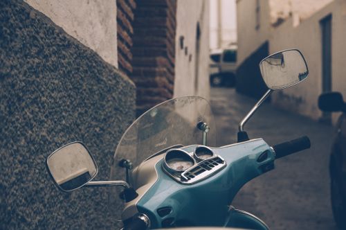 Free Close-up of a classic Vespa scooter in a narrow alley in Madrid, Spain. Stock Photo