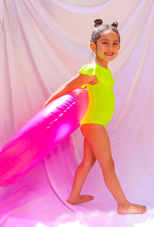 A Girl in Green Swimwear Holding a Floater