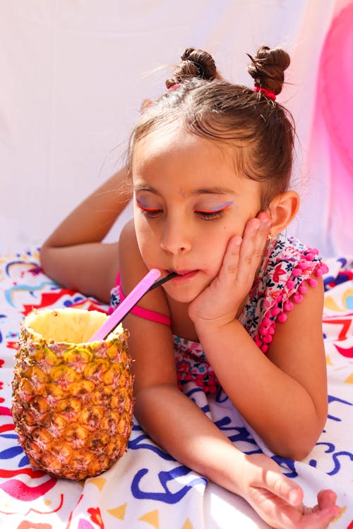 A Girl in a Swimsuit Drinking from a Pineapple