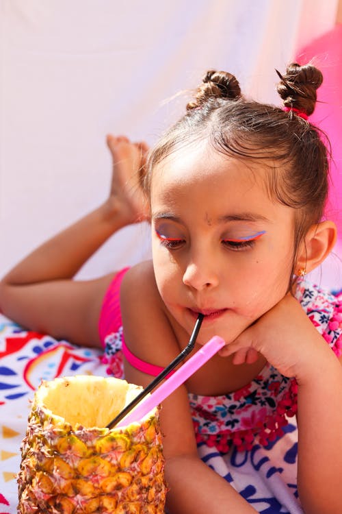 A Girl in a Swimsuit Drinking from a Pineapple