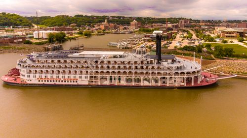 Free Aerial shot of the American Queen steamboat moored at Dubuque harbor, capturing the scenic view of the surroundings. Stock Photo