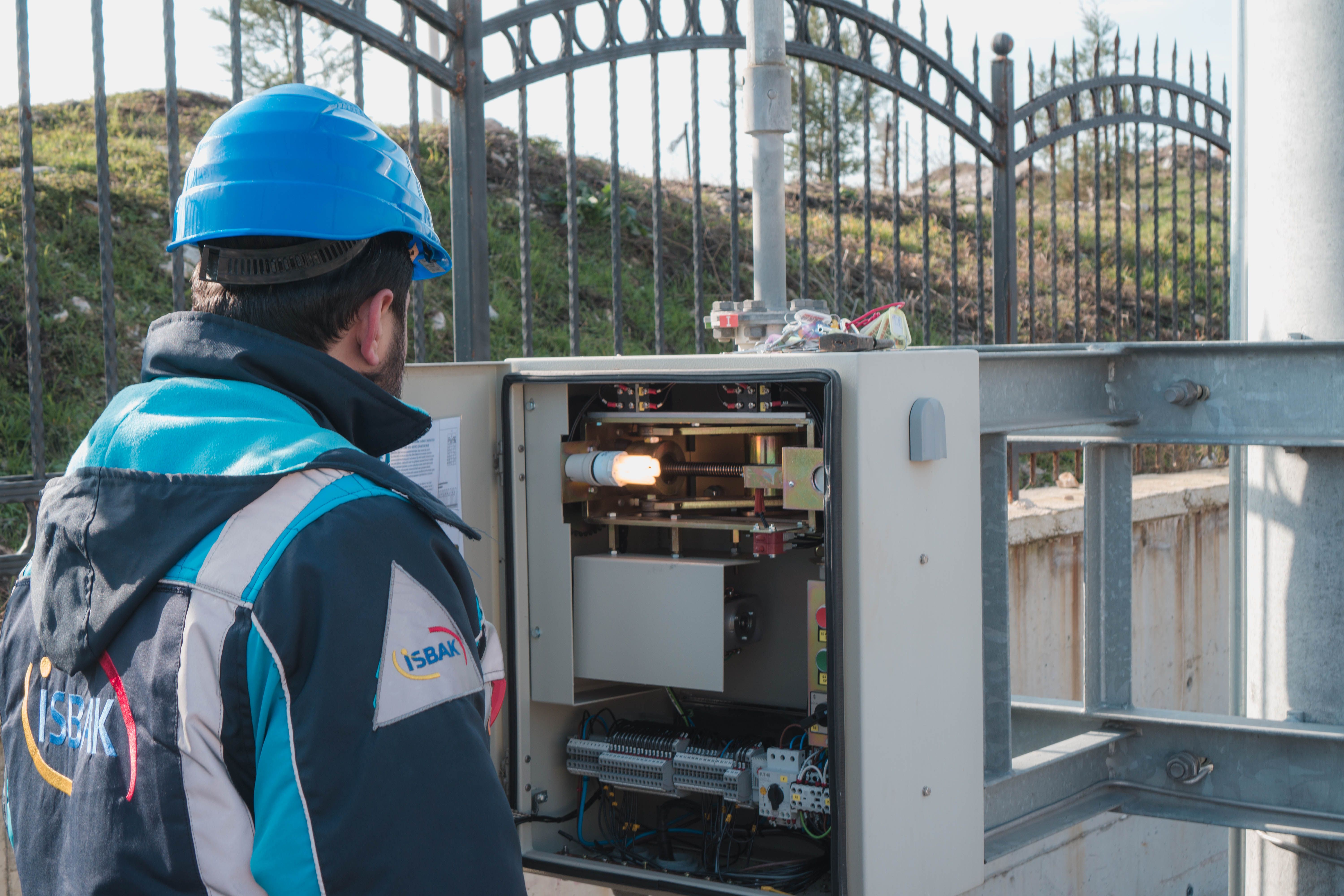 Image Name Licensed electrician inspecting an outdoor electrical control panel installation
