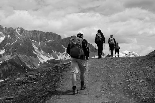 Grayscale Photo of People Hiking on the Mountain