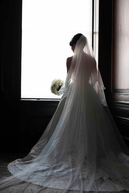 Free Back View of the Bride Standing Near the Window  Stock Photo