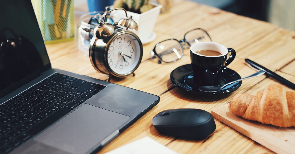 clock showing 7 AM with coffee cup and glass of water next to it