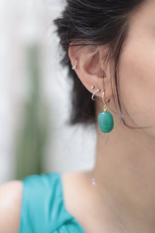 A Woman with Piercings and a Green Earring