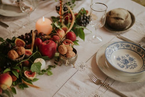 Table Setting with an Arrangement from Fruit, Leaves and Nuts in the Middle of the Table 