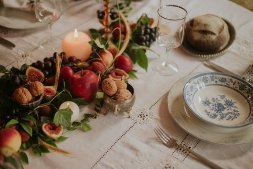 Free A rustic table set with fruit, walnuts and candles for an elegant dining experience. Stock Photo