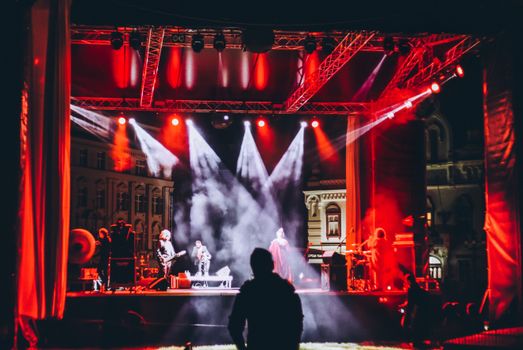 Live concert in Timișoara with vibrant lighting and enthusiastic audience at night.