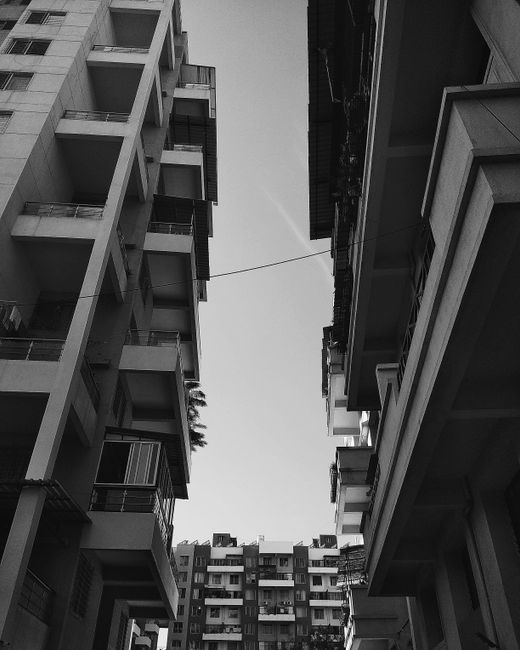 Black and white view of urban residential buildings and clear sky.