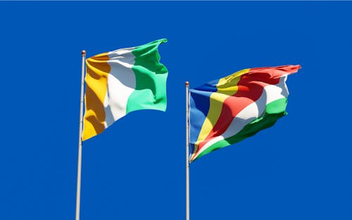 Ivory Coast and Seychelles Flags Under the Blue Sky