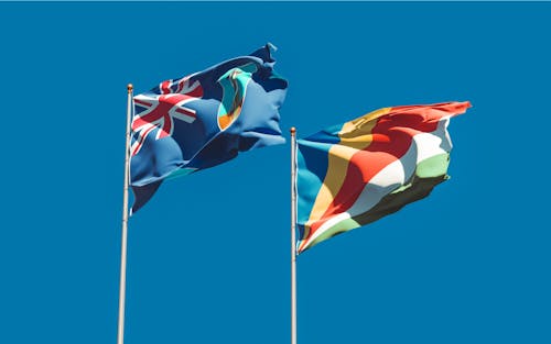 Country Flags on Poles Under Blue Sky