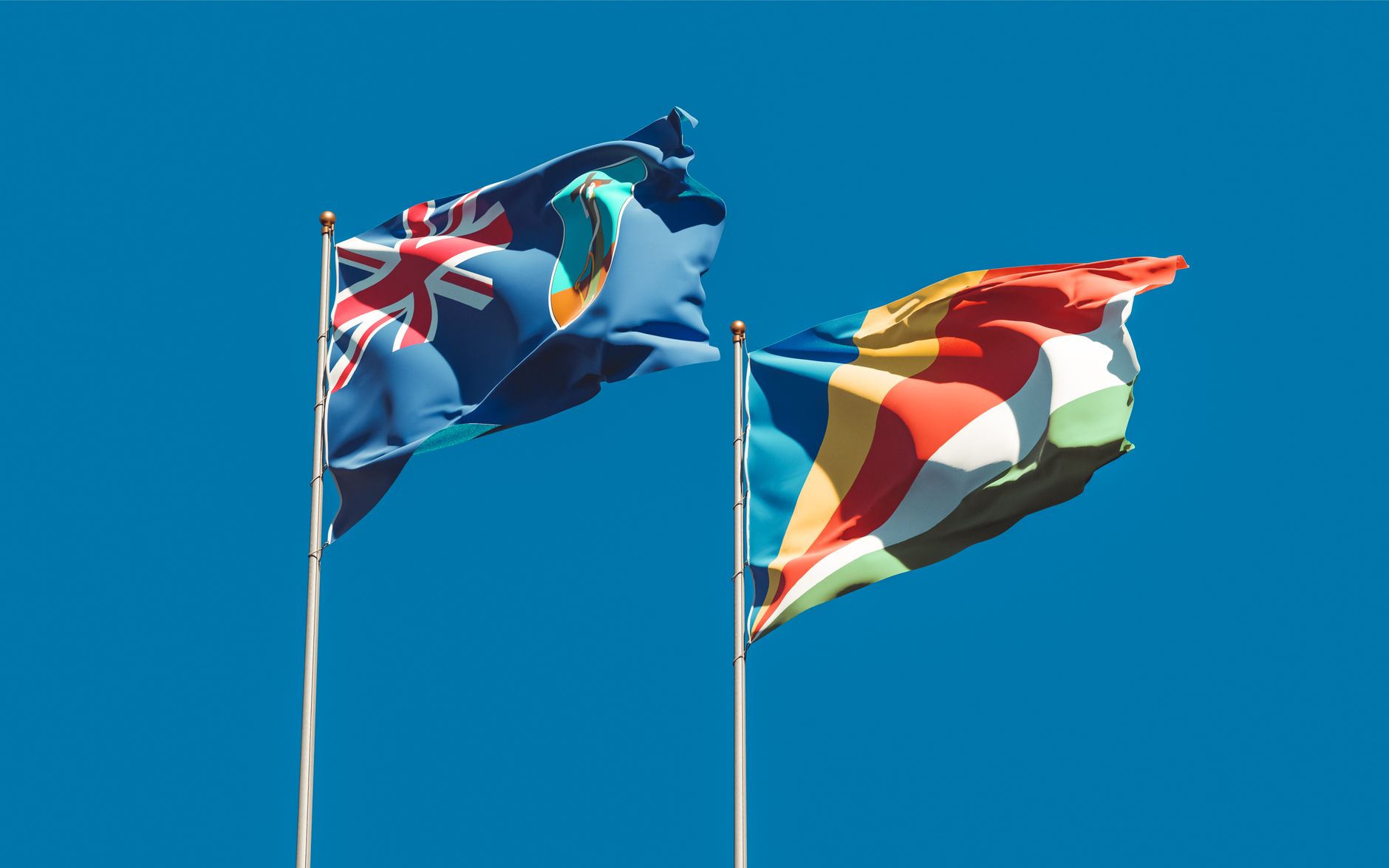 National flags of New Zealand and Seychelles waving against a vibrant blue sky, symbolizing national identity and unity. — free online jigsaw puzzle on JigsawPuzzlesFreeOnline.org
