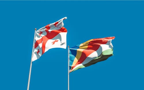 Free Hanging Flag of Georgia Beside the Seychelles Flag  Stock Photo