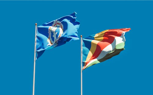 Free Northern Mariana Islands and Seychelles Flags Under the Blue Sky Stock Photo