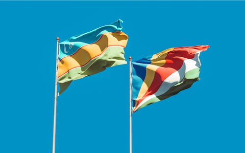 Free Hanging Flags of Karakalpakstan and Seychelles  Stock Photo
