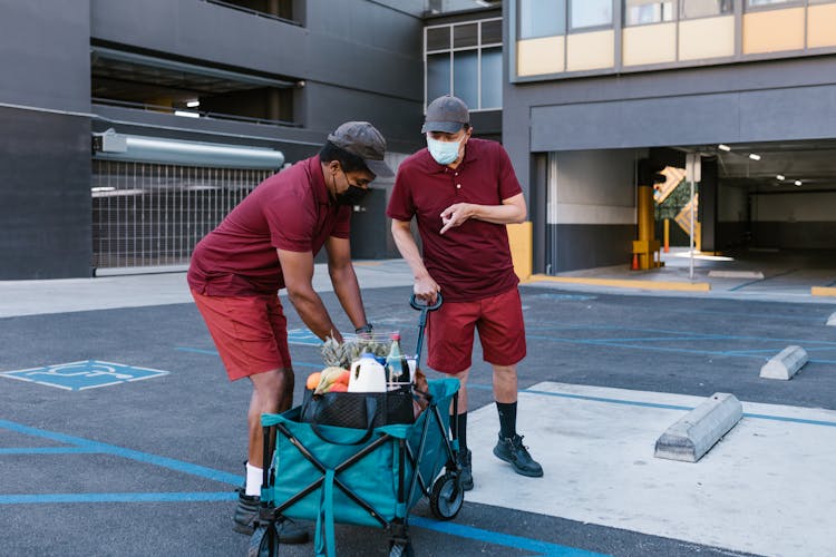 Men In Maroon Shirt And Shorts Delivering Food